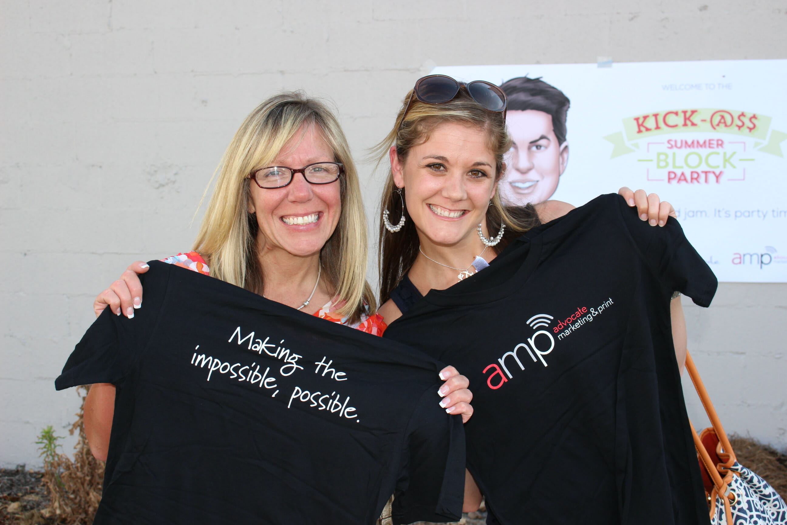 two advocate marketing and print employees posing with their new company T shirts.