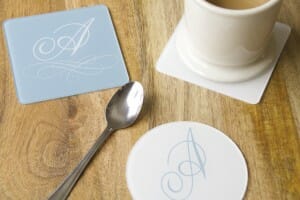 monogrammed coaster on a table with a tea cup and spoon