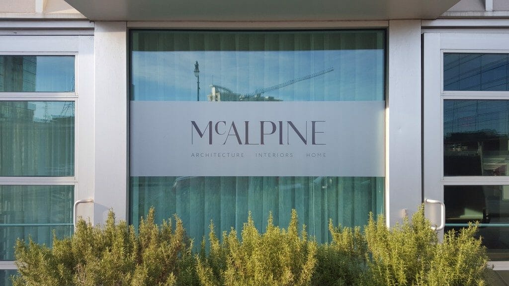 A frosted glass logo on Mcalpine architecture's building.