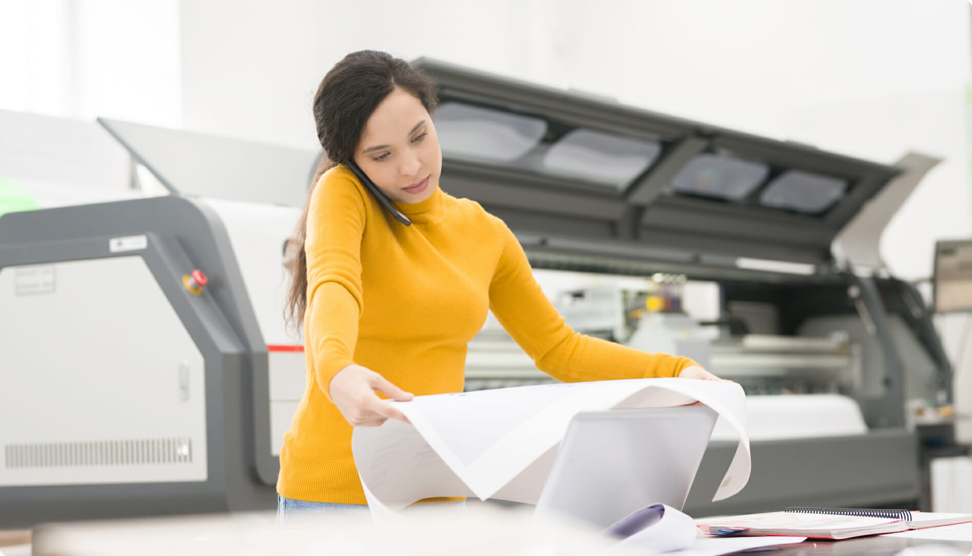 woman wearing yellow working with a wide format printer