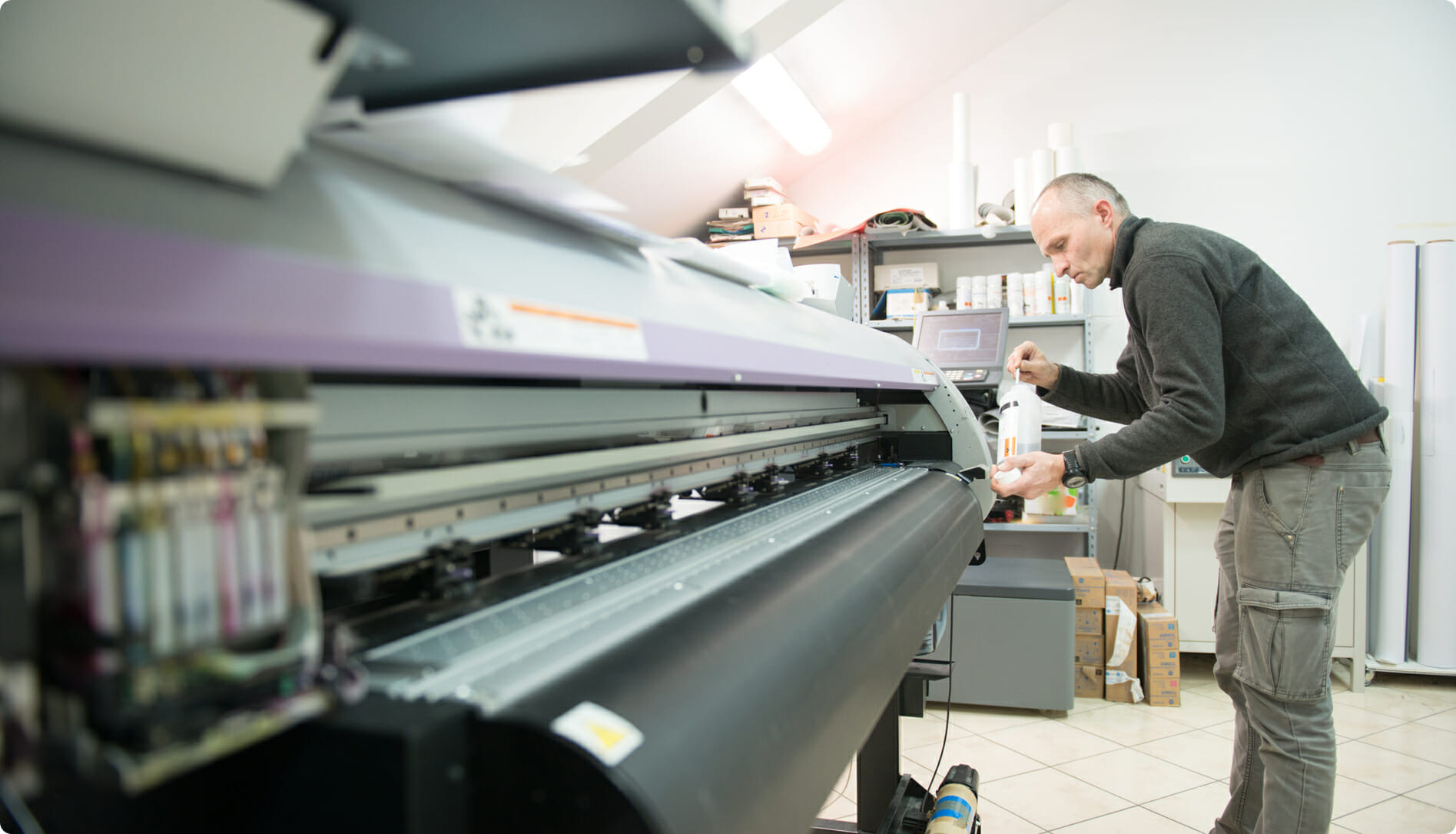 man working with a large format printer